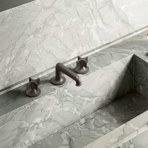 Single-hole Flora lavatory faucet by Fantini in chrome on a stone vanity