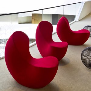 Nautile guest chair seen head on, slim and tall against a lobby wall