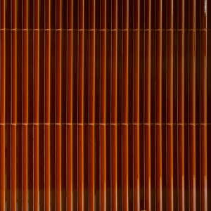 Shadow play across the ribbed Rombini wall in an office lobby