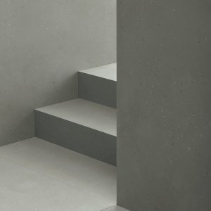 Primavera Nero floor against a Grigio wall with a leather chair