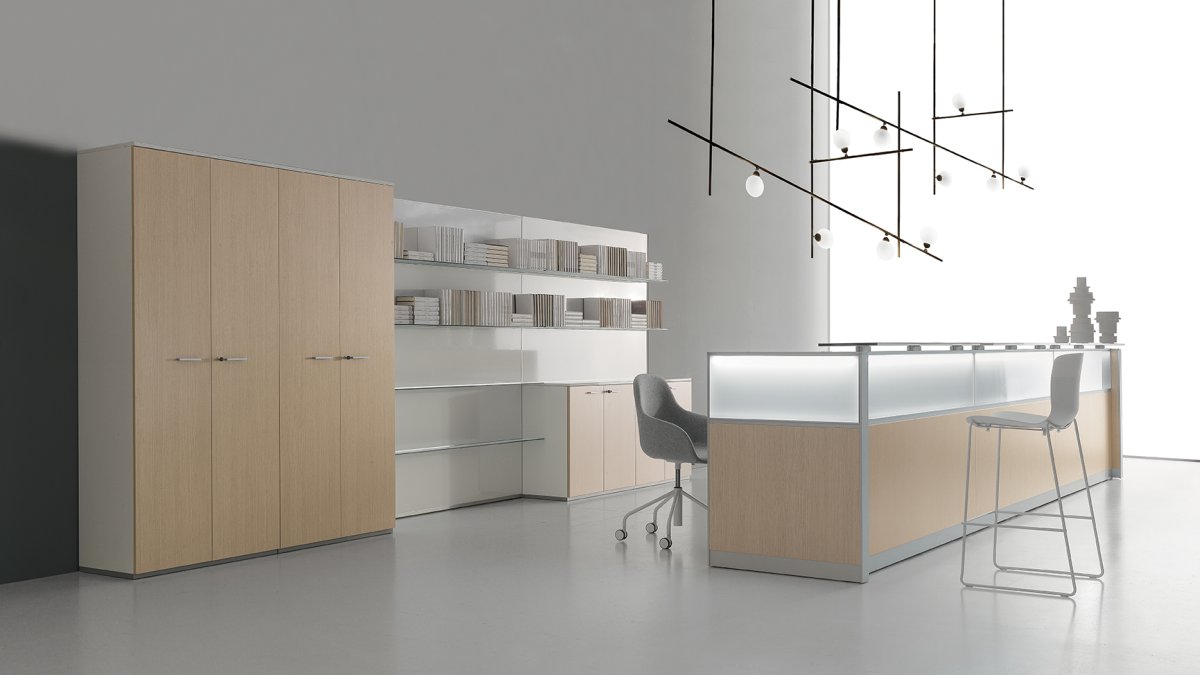 Reception desk with a backlit frosted-glass front, light oak cabinets and open shelving