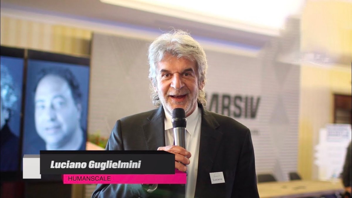 Luciano Guglielmini of Humanscale speaking into a microphone at an event