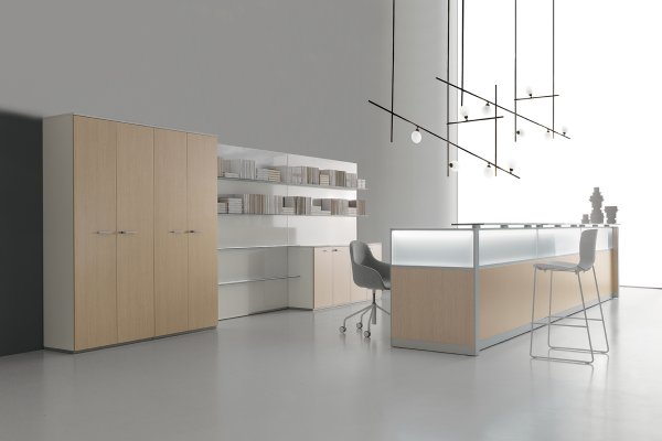 Reception desk with a backlit frosted-glass front, light oak cabinets and open shelving