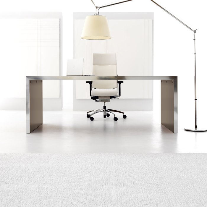 Modern Italian executive desk with slim matte top and integrated cable management in a glass-walled American corner office