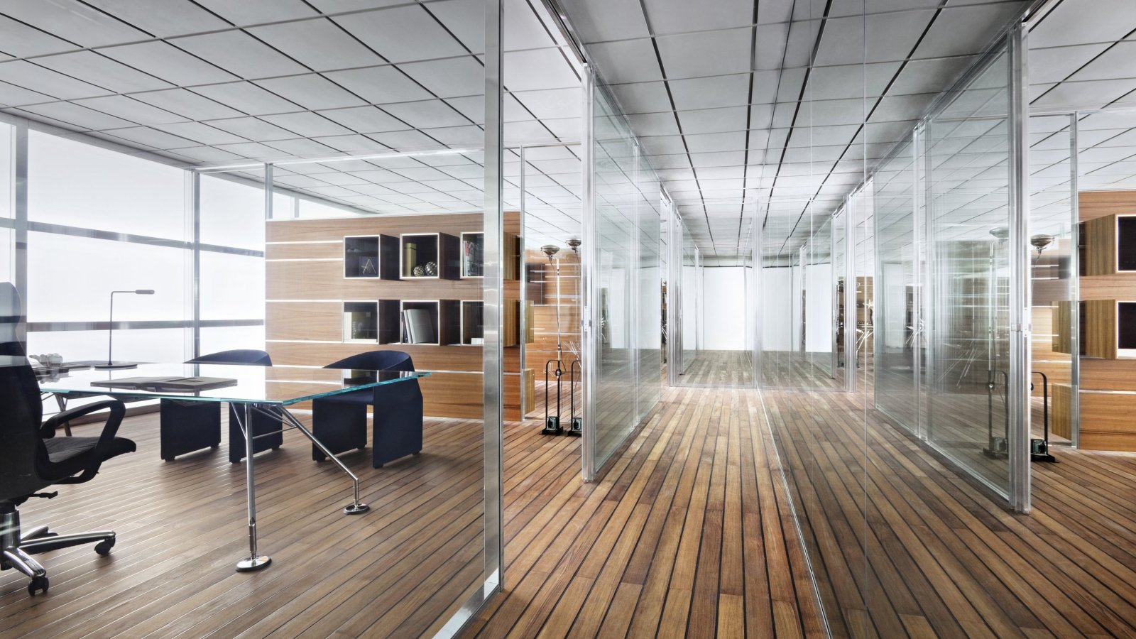 Executive office furnished in Italian design, with wood storage units and glass partition walls